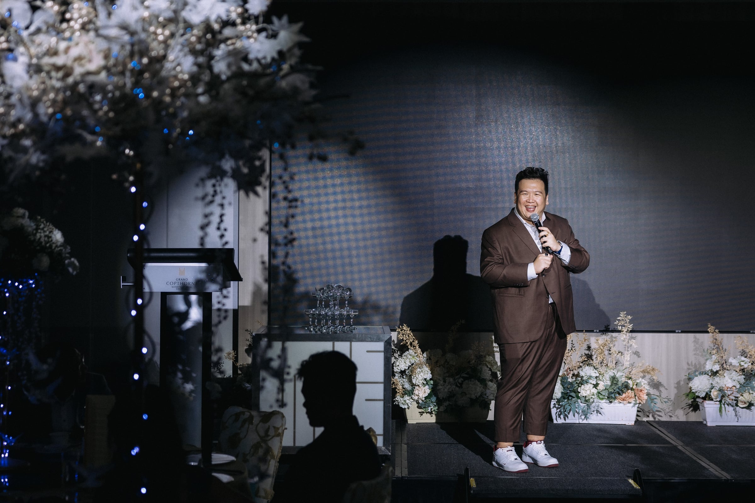 Emcee Dixon hosting bilingually on a Singapore ballroom stage