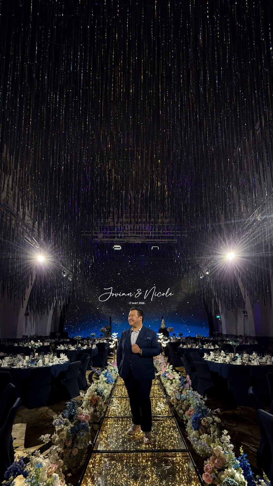 Emcee Dixon on a glowing walkway under a starry backdrop at a Singapore ballroom wedding